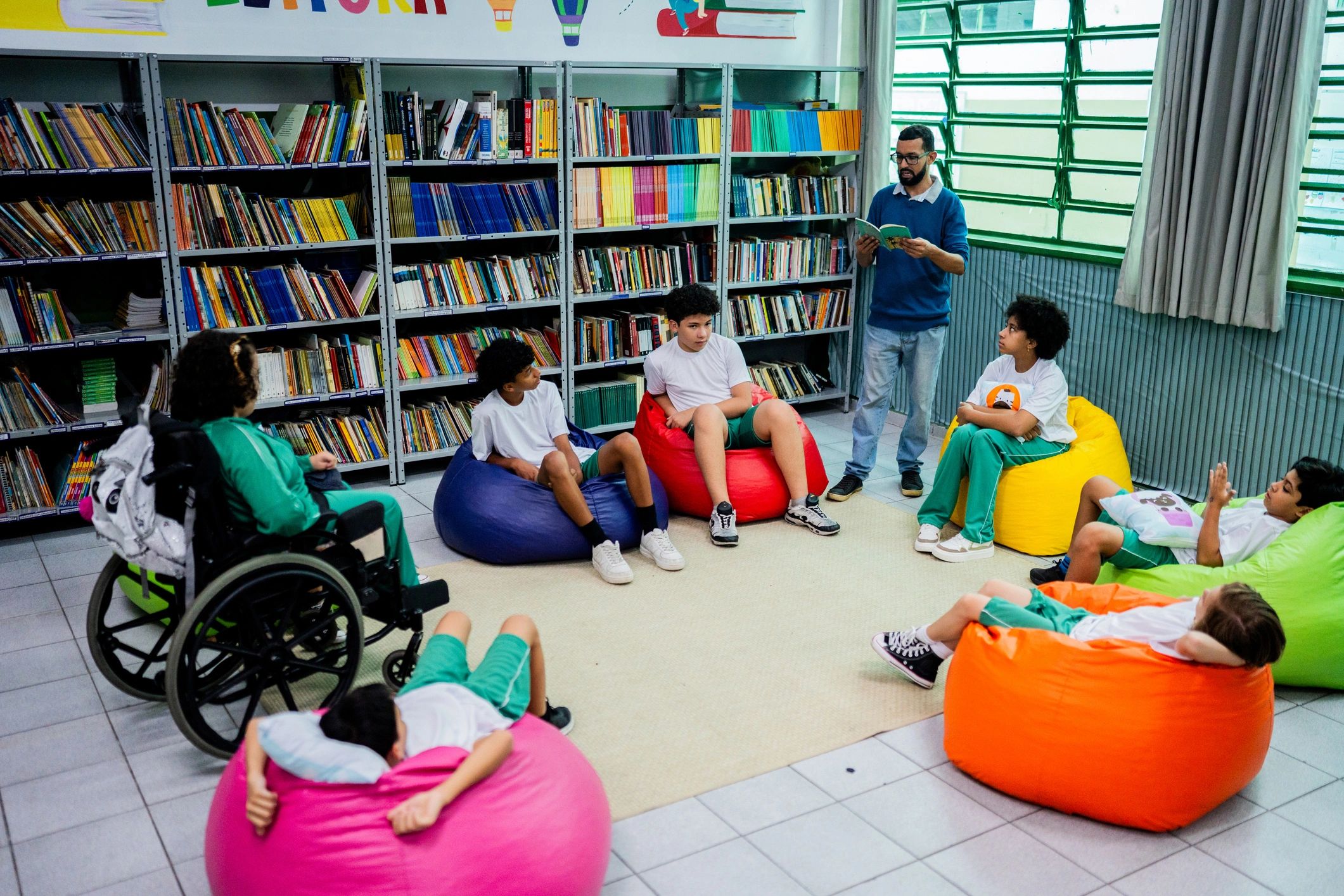Teacher reading with children gathered on the floor and beanbags in a warm, welcoming learning space
