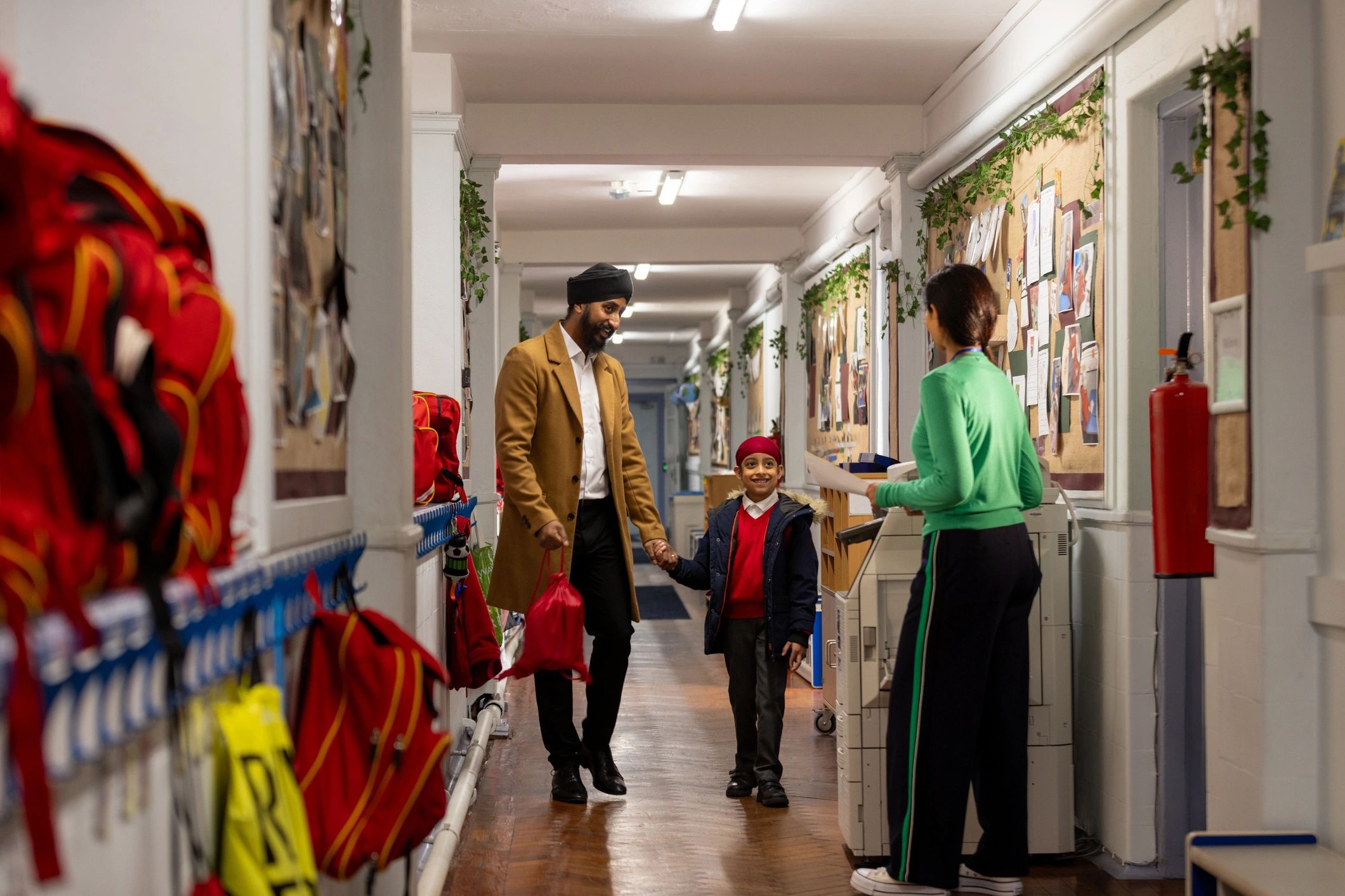 Parent and child walking through an elementary school hallway